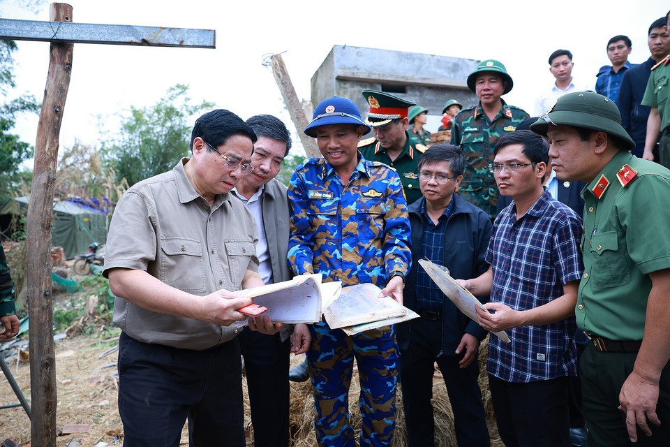 越南政府总理范明政察看为受洪水影响群众修建防洪避灾房屋的方案。图自越通社