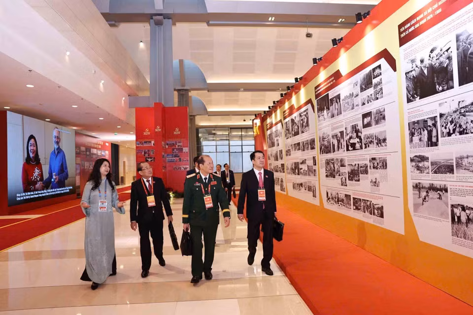 与会代表参观了由越通社举办的《在党的旗帜下——国家迈入新时代》图片展。图自越通社