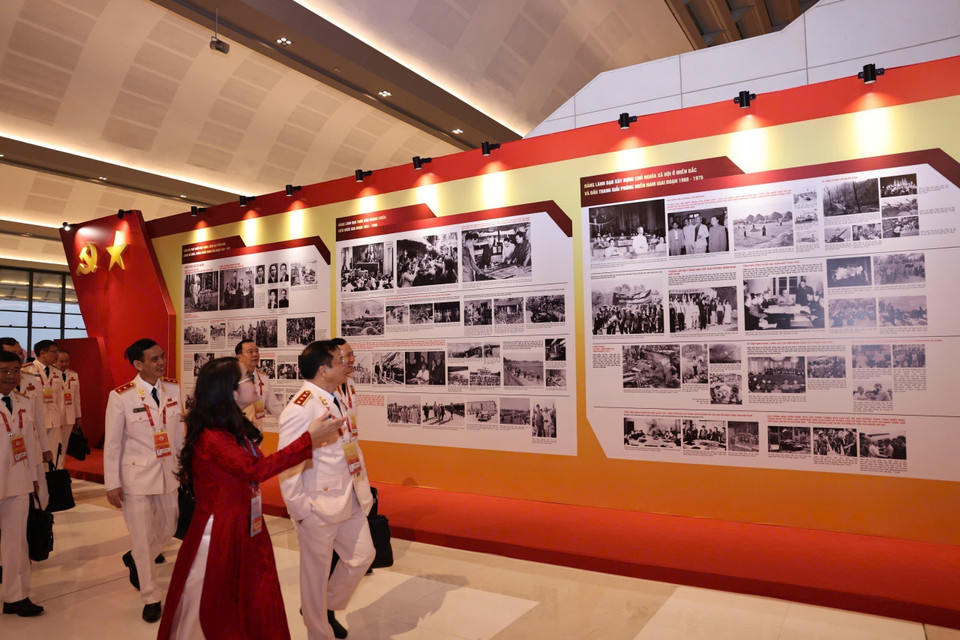 在越南共产党第十四次全国代表大会预备会议开幕前，与会代表参观了由越通社举办的《在党的旗帜下——国家迈入新时代》图片展。图自越通社