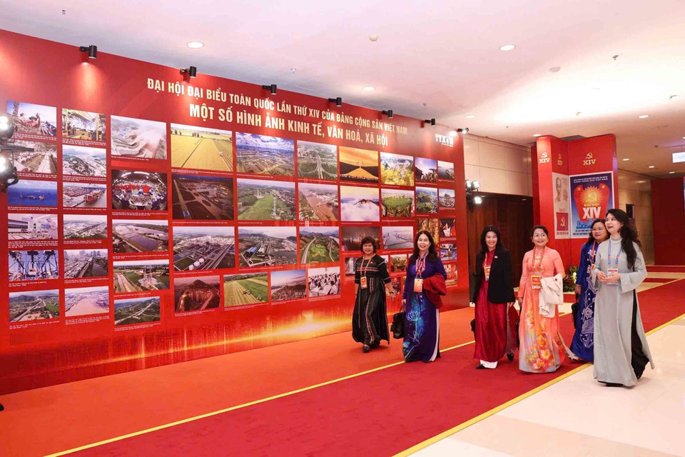 在越南共产党第十四次全国代表大会预备会议开幕前，与会代表参观了由越通社举办的《在党的旗帜下——国家迈入新时代》图片展。图自越通社