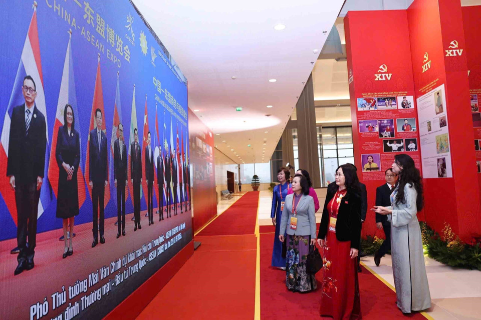 在越南共产党第十四次全国代表大会预备会议开幕前，与会代表参观了由越通社举办的《在党的旗帜下——国家迈入新时代》图片展。图自越通社