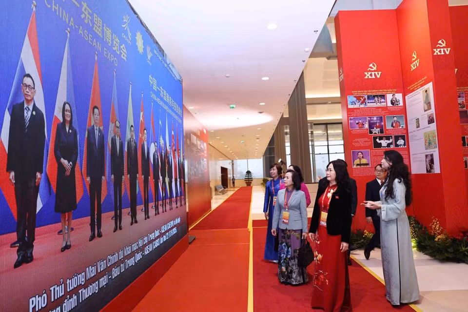 在越南共产党第十四次全国代表大会预备会议开幕前，与会代表参观了由越通社举办的《在党的旗帜下——国家迈入新时代》图片展。图自越通社