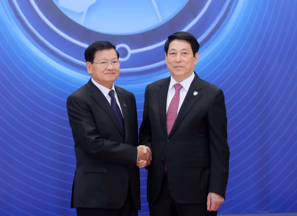 10月25日上午，越南国家主席梁强迎接出席《河内公约》开放签署仪式的老挝人民革命党中央总书记、国家主席通伦·西苏里。图自越通社