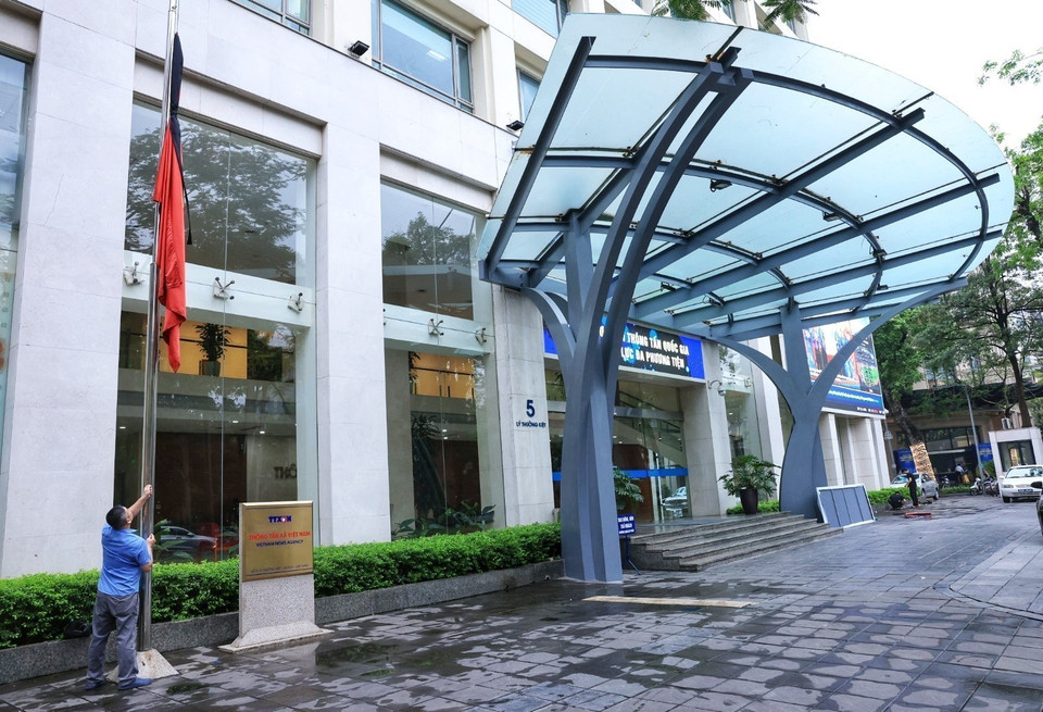 在越南通讯社总部举行的为原国家主席陈德良举行国葬仪式的降半旗仪式。图自越通社