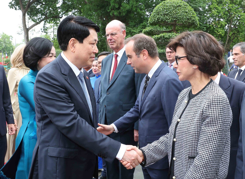 越南国家主席梁强与法国代表团成员握手。图自越通社