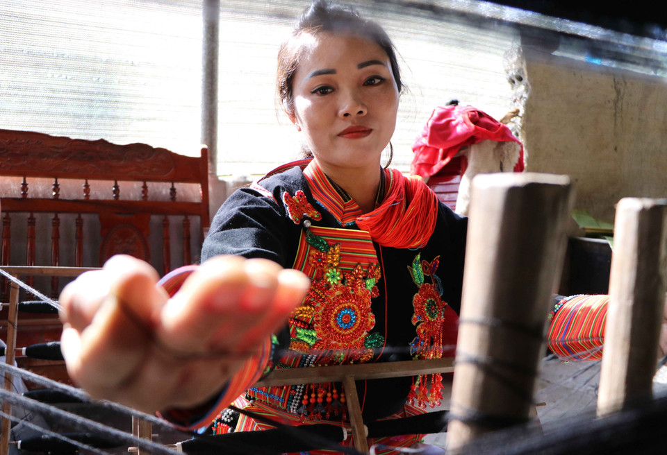 在纺线过程中，妇女们要将纤维分开，去除杂质，形成纤维条。图自越通社