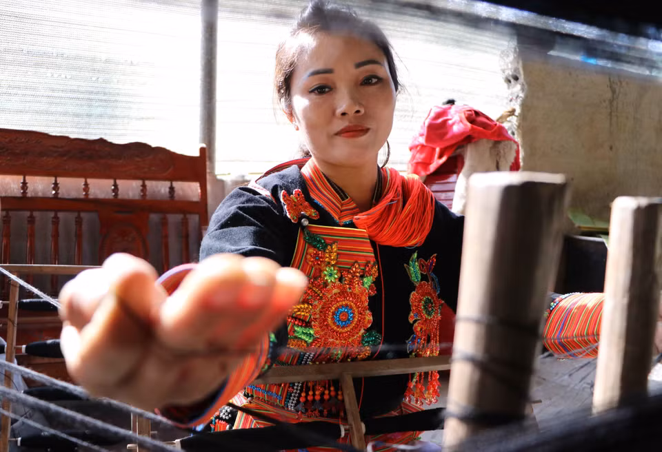 在纺线过程中，妇女们要将纤维分开，去除杂质，形成纤维条。图自越通社