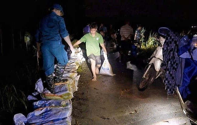 驻守当地的第3师第2团干部、战士通宵值守,支援受灾群众。图自越通社
