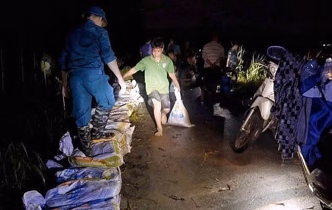 驻守当地的第3师第2团干部、战士通宵值守，支援受灾群众。图自越通社