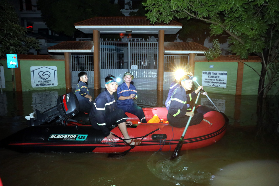 谅山省公安厅干部、战士连夜出动,在失契乡洪灾地区支援群众。图自越通社