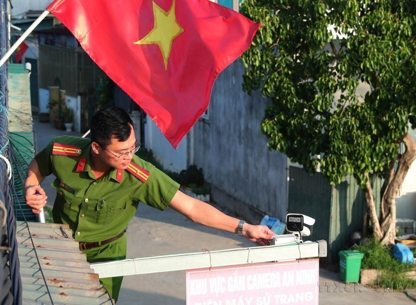 义安省胡坚忠少校检查并维护安装在各村落的职能报警摄像头。图自越通社