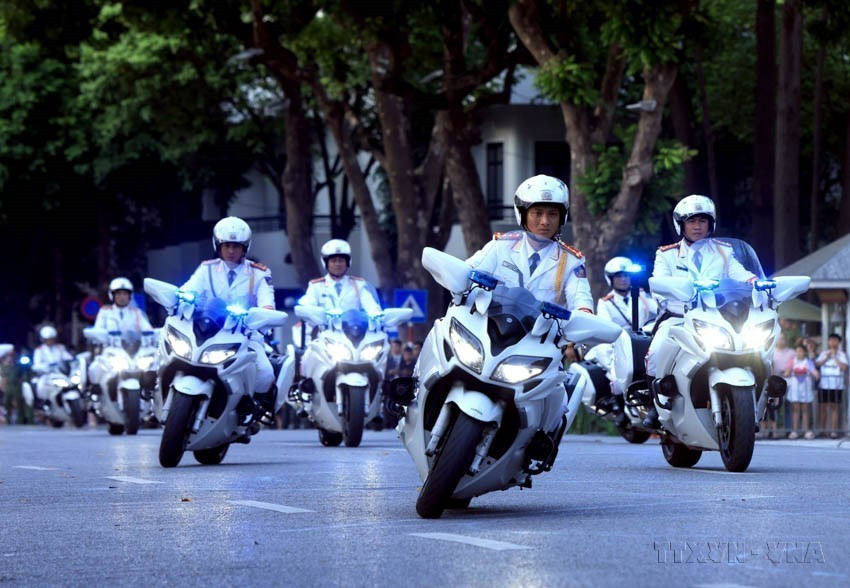 来自公安部警卫司令部的战士在河内还剑湖步行街表演摩托车之字形绕桩驾驶。图自越通社