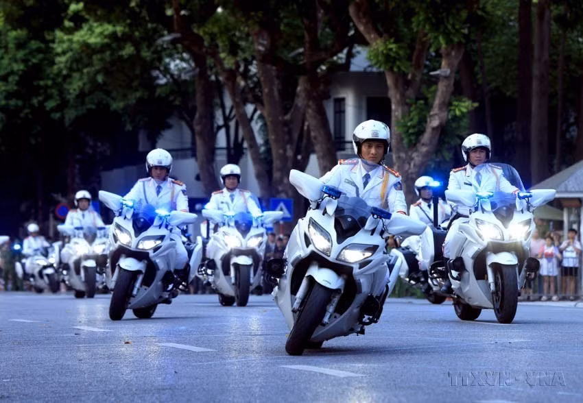 来自公安部警卫司令部的战士在河内还剑湖步行街表演摩托车之字形绕桩驾驶。图自越通社