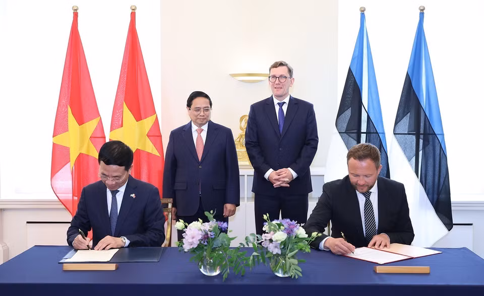 越南政府总理范明政与爱沙尼亚共和国总理克里斯滕·米哈尔共同见证两国外交部合作文件签署仪式。图自越通社