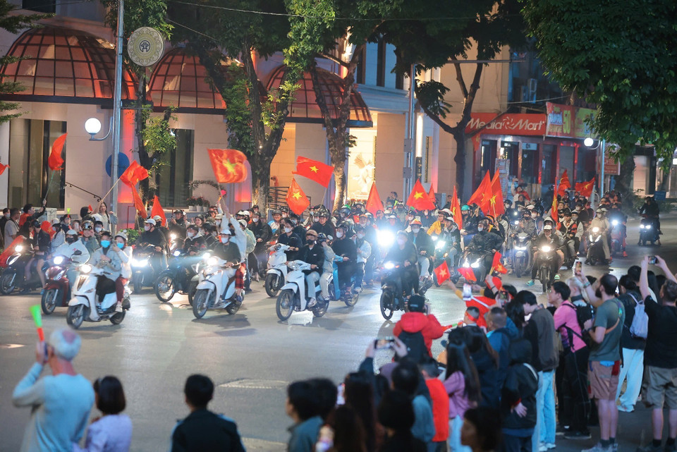 街道上人潮涌动，人们兴高采烈挥着金星红旗国旗，庆祝越南男足球队的胜利。图自越通社