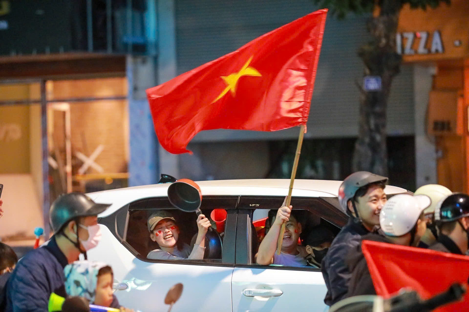 街道上人潮涌动，人们兴高采烈挥着金星红旗国旗，庆祝越南男足球队的胜利。图自越通社
