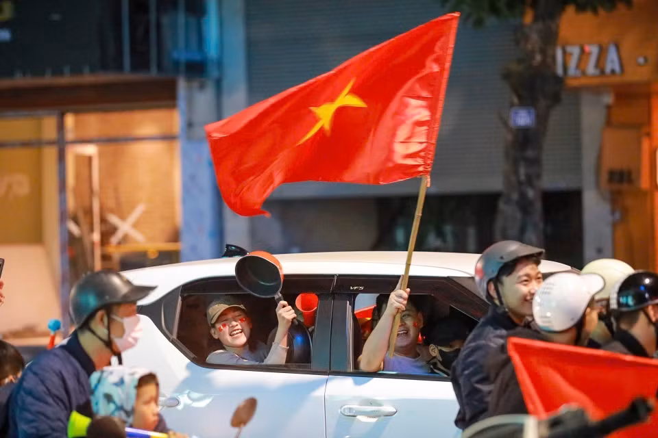街道上人潮涌动，人们兴高采烈挥着金星红旗国旗，庆祝越南男足球队的胜利。图自越通社