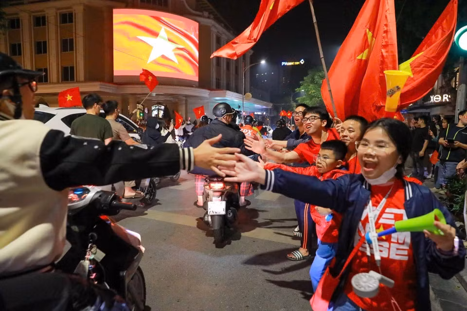 越南首都人民兴高采烈涌向市中心各条街道，挥着国旗、点燃烟火、吹响喇叭，庆祝这场胜利。图自越通社
