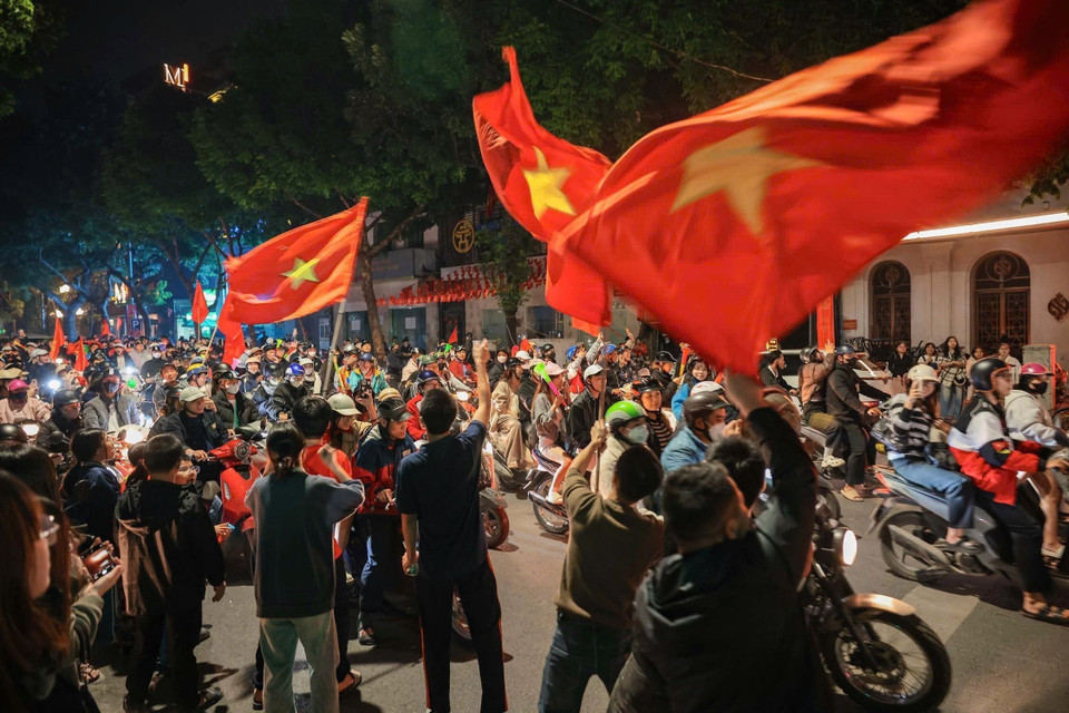 街道上人潮涌动，人们兴高采烈挥着金星红旗国旗，庆祝越南男足球队的胜利。图自越通社