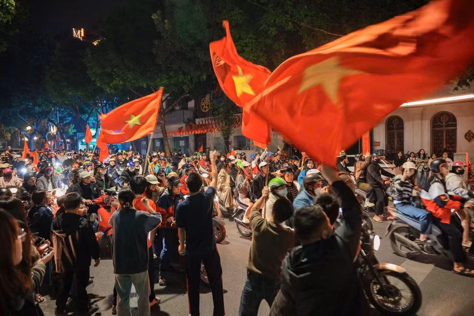 街道上人潮涌动，人们兴高采烈挥着金星红旗国旗，庆祝越南男足球队的胜利。图自越通社