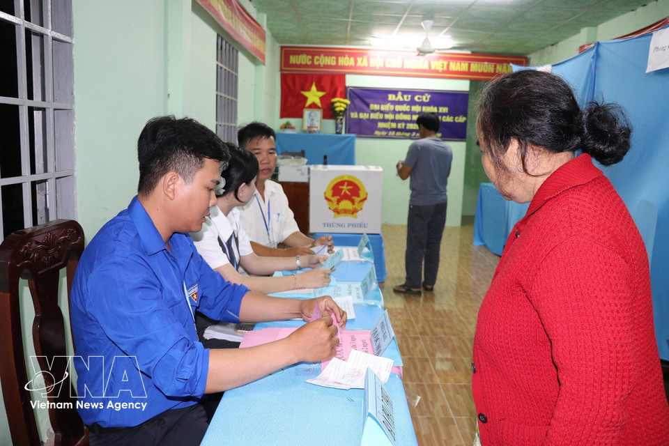 同塔省新富东乡居民一大早前来投票点，参加国会代表及各级人民议会代表投票选举。图自越通社