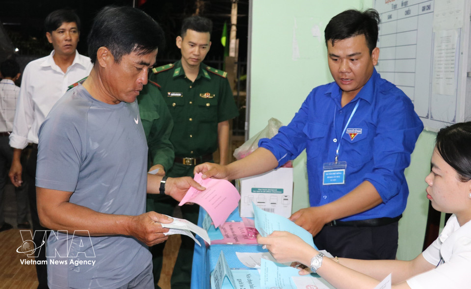 同塔省新富东乡居民一大早前来投票点，参加国会代表及各级人民议会代表投票选举。图自越通社