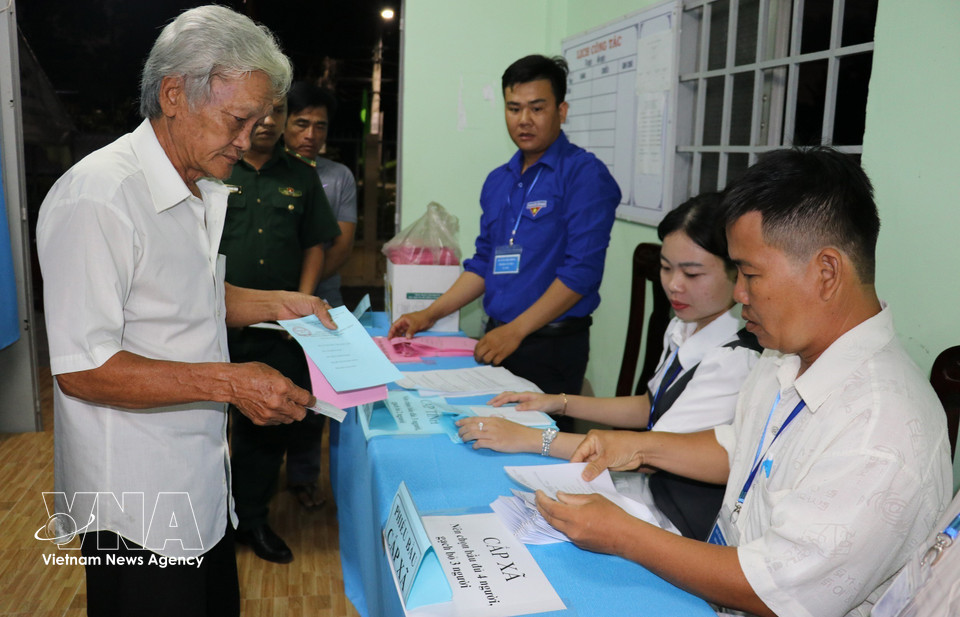 同塔省新富东乡居民一大早前来投票点，参加国会代表及各级人民议会代表投票选举。图自越通社