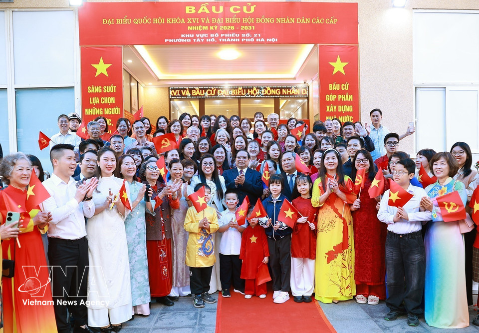 越南政府总理范明政夫妇与西湖坊第21号投票站选民合影。图自越通社