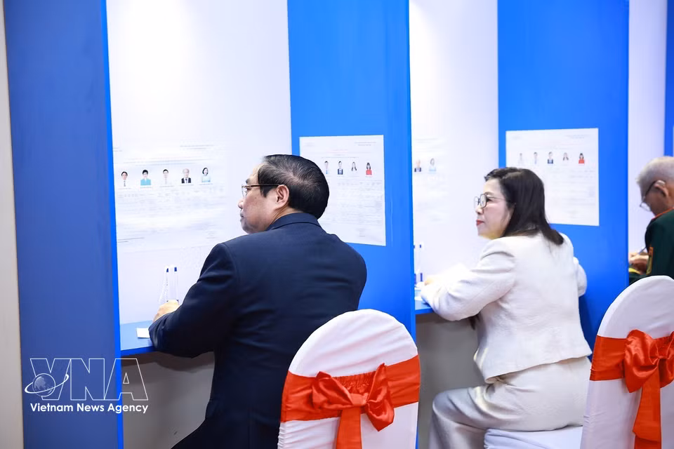 越南政府总理范明政夫妇在河内西湖坊第21号投票站行使公民选举权。图自越通社