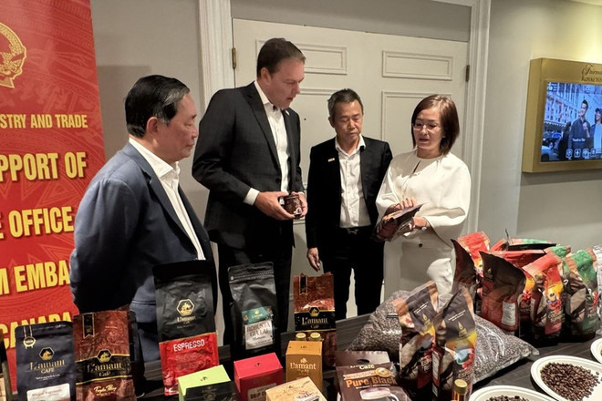 越南驻加拿大商务参赞陈秋琼向加拿大咖啡协会主席罗伯特·卡特介绍越南咖啡。图自越通社 img-9601-8536.jpg