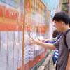 岘港技术教育大学的大学生们正在研究学校张贴的候选人名单。图自越通社