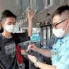 河内交通运输公司的员工使用手持设备销售和管理公交车票。图自hanoimoi.com