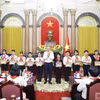 越共中央总书记、国家主席苏林向胡志明少年先锋队优秀队员赠送《胡伯伯与儿童》图片。图自越通社