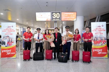 越捷航空领导与机组人员和乘客合影。越捷航空供图