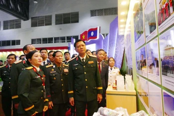 越南和老挝国防部领导参观2025年越南—老挝企业贸易对接与产品展销会上的展位。图自越通社