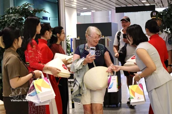 向菲律宾马尼拉和印度尼西亚巴厘岛直飞岘港市的两架航班上国际游客赠送礼物。图自越通社