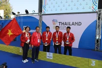 越南文化、体育与旅游部副部长黄道刚与代表团团长黎氏黄燕同夺得金银铜奖牌的3名运动员合影留念。图片来源：越通社