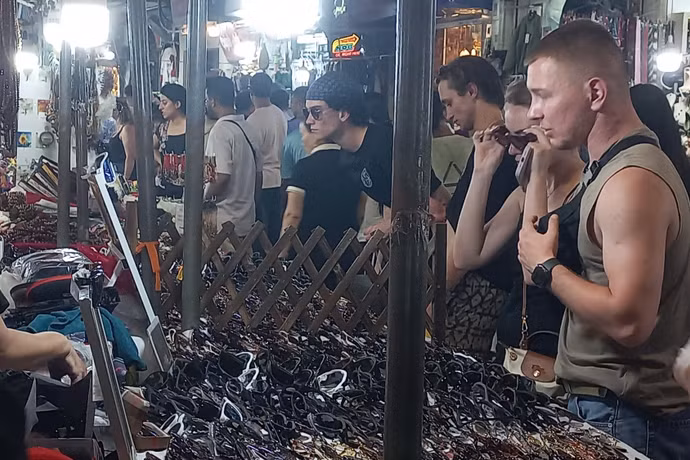 国际游客在河内古街夜市选购纪念品。图自越通社