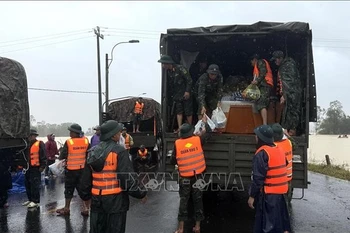 公安力量向庆和省博爱西乡的洪水灾区居民运送救援物资。图自越通社