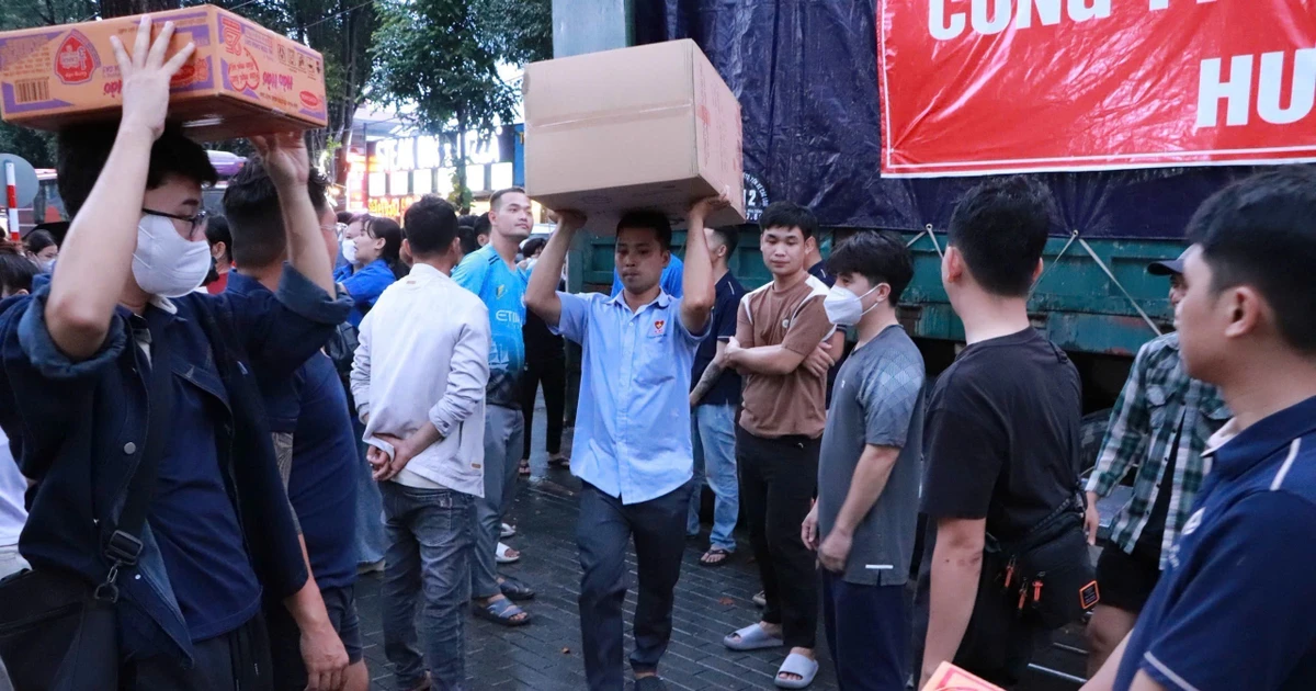 志愿者们正忙碌地将80吨物资和生活必需品装上救援车辆，送往灾区。（图片来源：越通社）