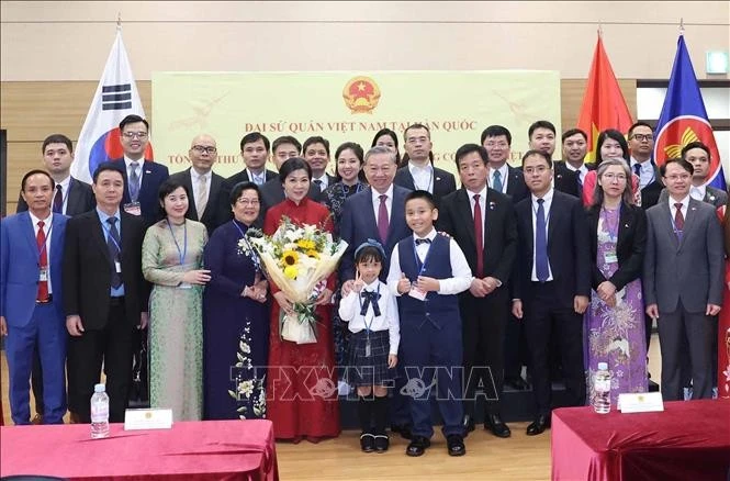 越共中央总书记苏林及夫人与越南驻韩国大使馆干部人员和旅韩越南人代表合影留念。（图片来源：越通社）