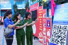 胡志明市年轻选民通过扫描二维码（QR码）参加《选举法》在线知识竞赛。图自越通社