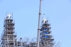 西贡圣母大教堂两座重达800多公斤的镀金十字架已成功安装在约60米高处的锌制塔尖上。图自越通社