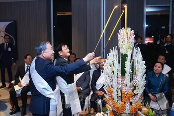 越共中央总书记苏林同通伦·西苏里共同进行老挝传统拴线仪式。 图片来源：越通社