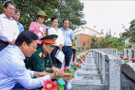 西宁省人民委员会副主席范晋和（左一）与工作团在安静烈士陵园（西宁省安静坊）核查未确定身份烈士墓的信息。图自越通社 