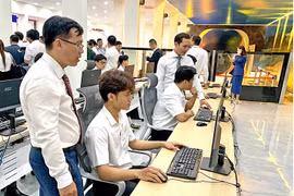 根据您提供的内容，这是一张图片说明，描述的是胡志明市交通运输大学的学生在新投入使用的高速铁路驾驶与运营模拟教室中进行学习的情景。图片来自tuoitre.vn。 按照中文新闻配图说明的习惯，可以译为： --- 胡志明市交通运输大学的学生在校方新投用的高速铁路驾驶与运营模拟教室内上课。图自tuoitre.vn 