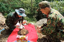 宣光省军事指挥部烈士遗骸搜寻归葬队对刚刚找到的烈士遗骸进行归集整理 图自《人民军队报》