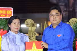 胡志明市团市委书记、胡志明市越南青年联合会主席吴明海向烈士家属移交烈士遗像。图自 muctim.tuoitre.vn