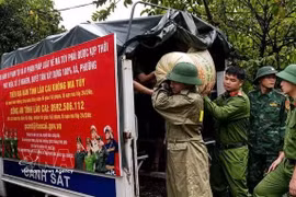 老街省巴刹乡公安干部和民警协助受灾群众转移财产至安全地点。 图自越通社