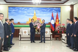 越南驻老挝大使阮明心转交越共中央总书记苏林致老挝人民革命党建党71周年的花篮。图自越通社